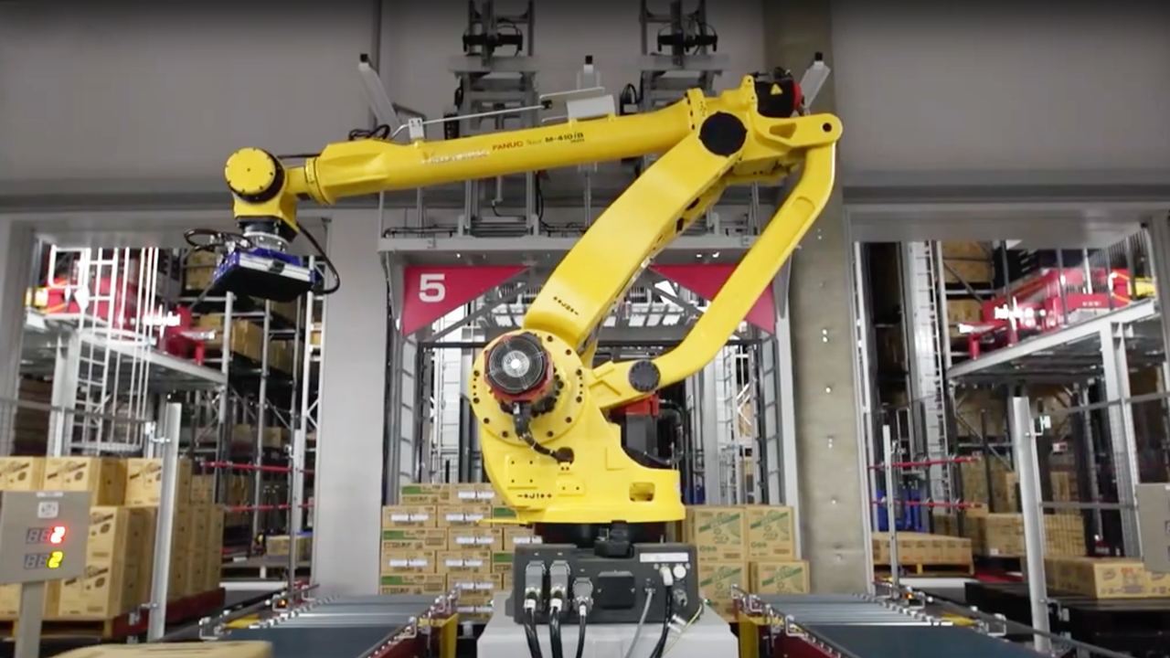 A yellow depalletizing robot moves to pick unload a full pallet
