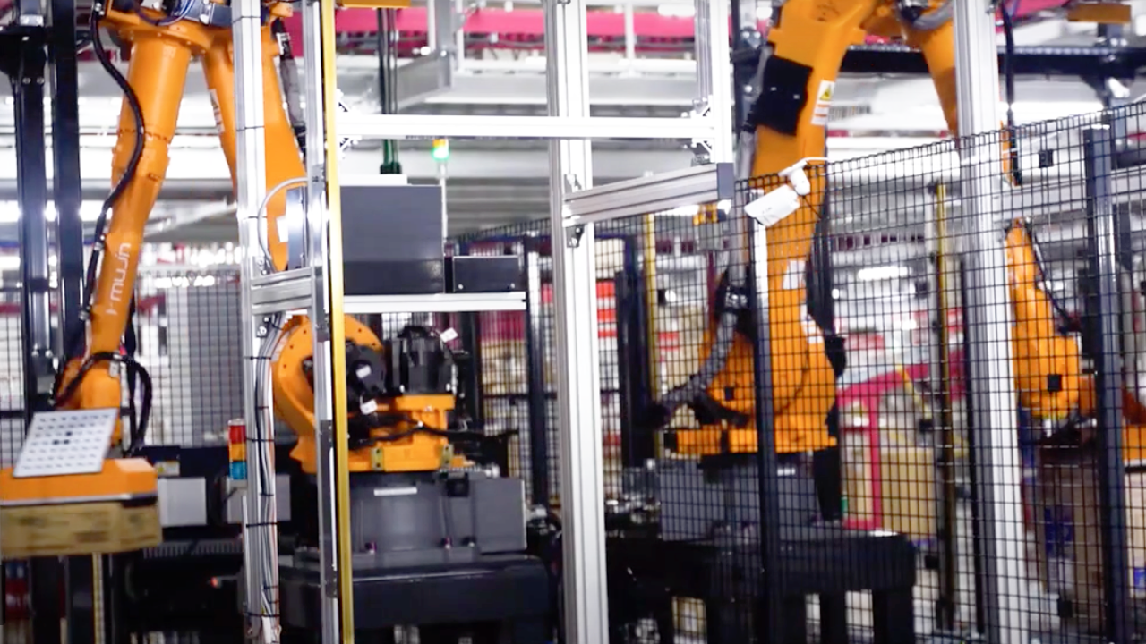 Palletizing robots picking up packages in a facility